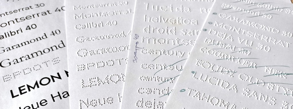 several pages of printed and embossed text in raised dots. Some text is readable, some is not due to the strange positioning of the dots on the paper