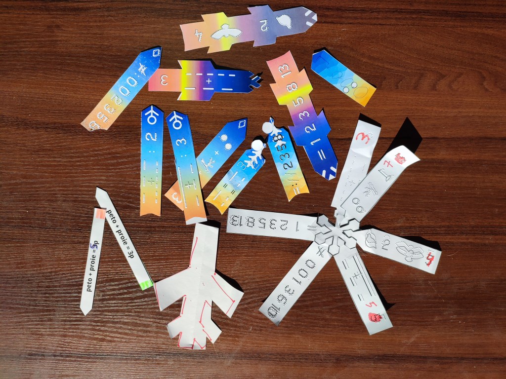 picture showing different shapes of scorig tiles. All are uite long, with oe end being flat or nearly flat, and the other more pointy or puzzle shaped