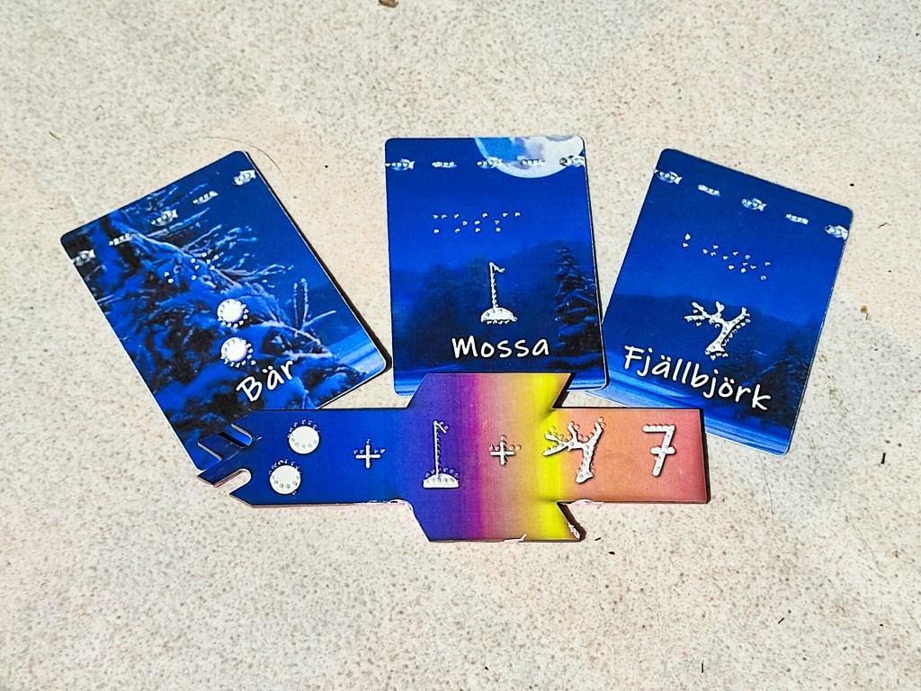 3 plant cards with the 3 different species in raised dot. Below is a scoring tile showing the same raised images followed by a tactile "7"